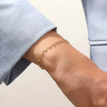 Model wearing a 14k gold textured chain bracelet, elegant with shimmering starburst accents.

