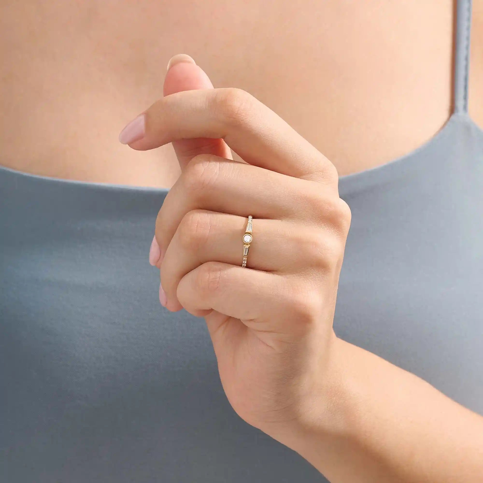 Model wearing a 14k solid gold bezel mixed cut promise ring, showcasing its sparkling moissanite stones and modern, elegant style.