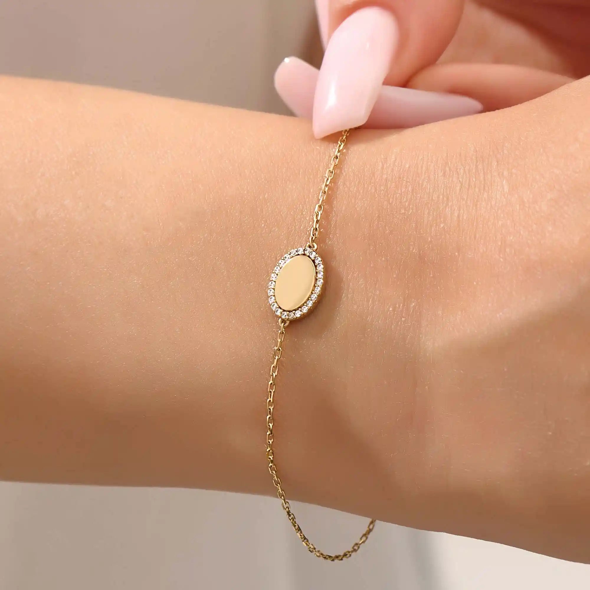 Model wearing a 14k yellow gold oval bracelet with pavé moissanite halo, adding refined sparkle to the wrist.
