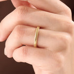 Model wearing a 14k gold vermeil minimalist band ring with ridged design, dainty gold stacking ring for women’s everyday look.
