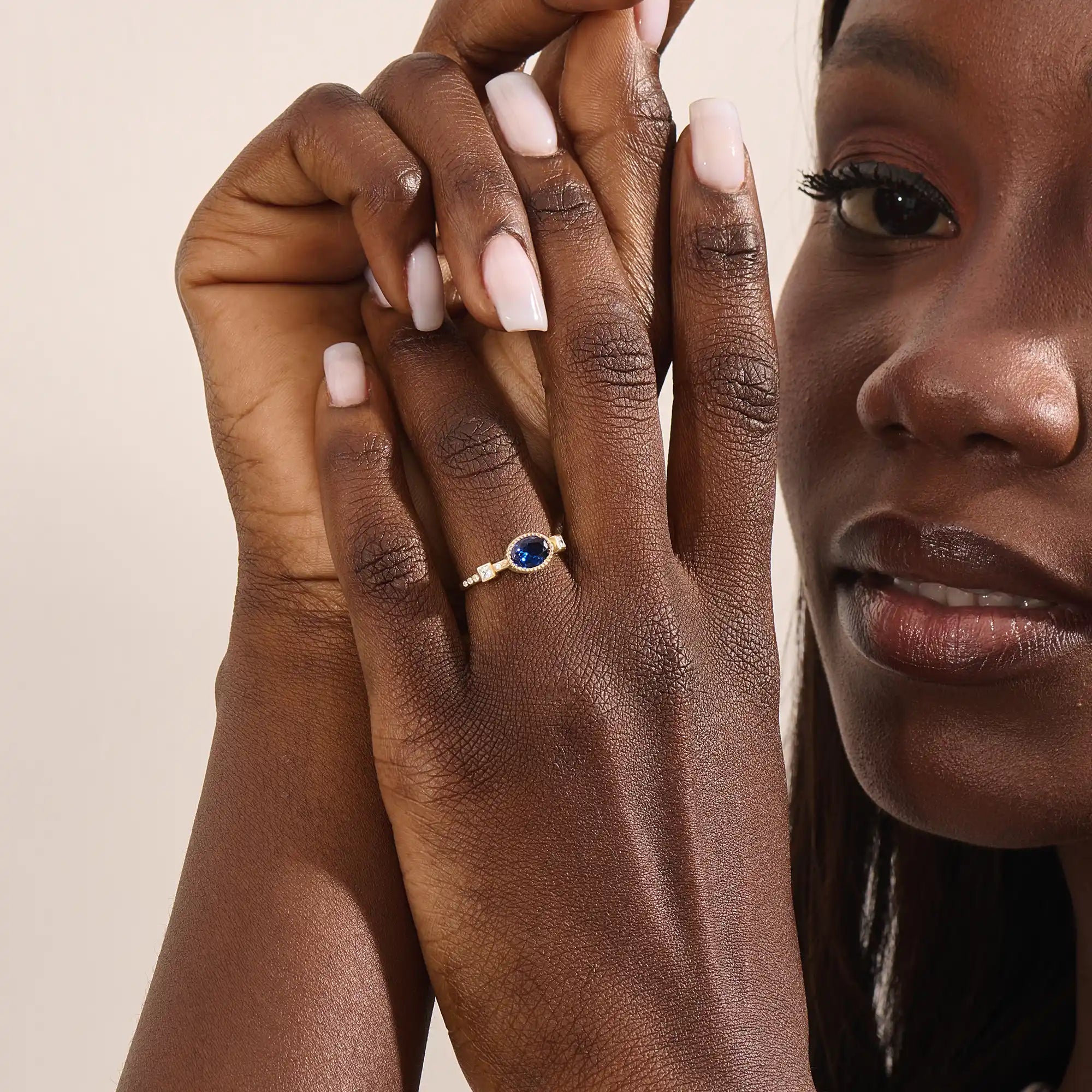 Model wearing a vintage bezel set oval sapphire ring with moissanite accents. Elegant 14k gold solitaire gemstone ring for everyday or engagement.
