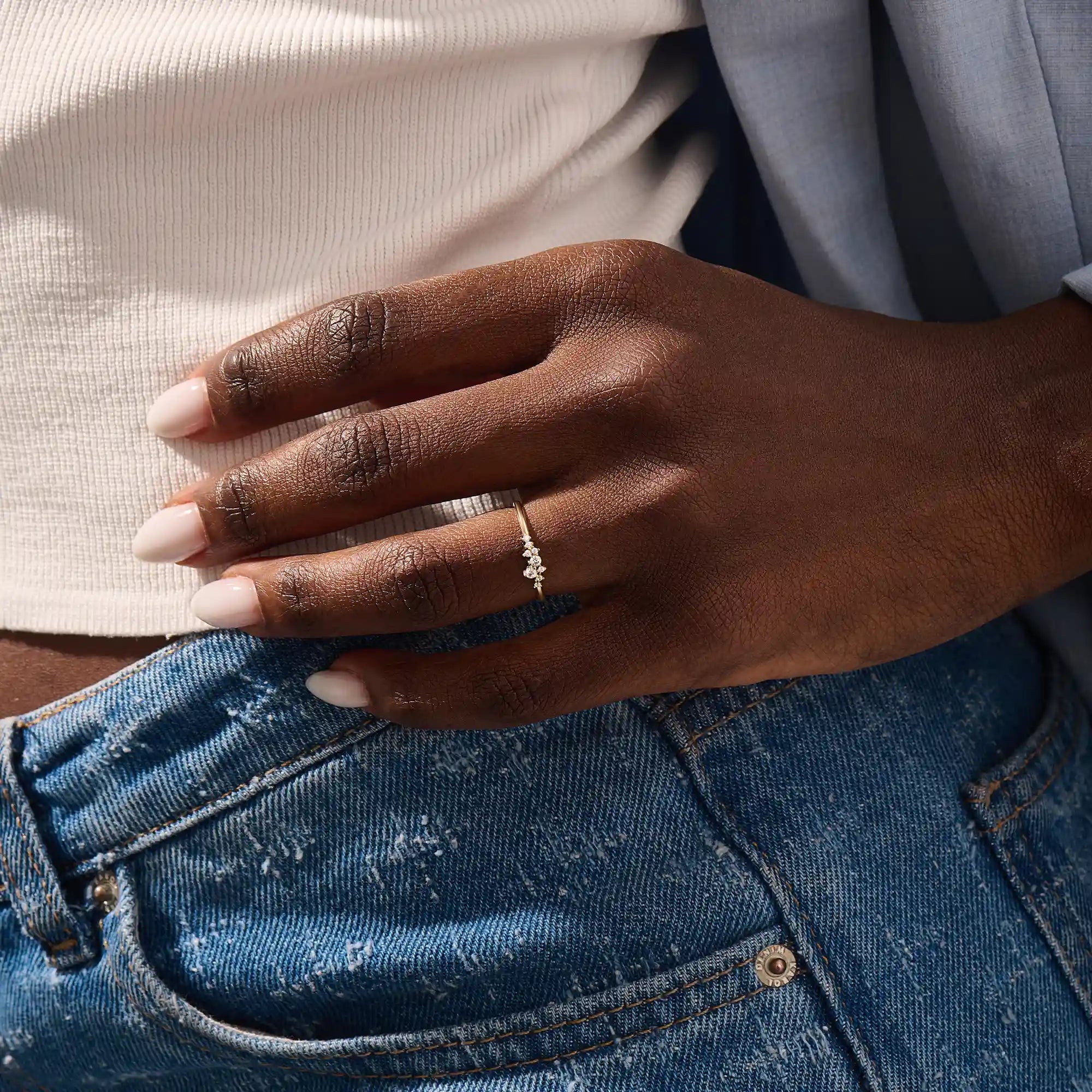 Model wearing minimalist cluster moissanite stacking wedding ring in 14k solid gold, showcasing a delicate round stone arrangement and sleek band design.
