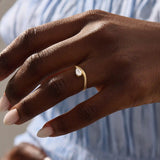 Model wearing pear cut moissanite solitaire engagement ring on a curved 14k solid gold band, highlighting its sleek and modern minimalist style.