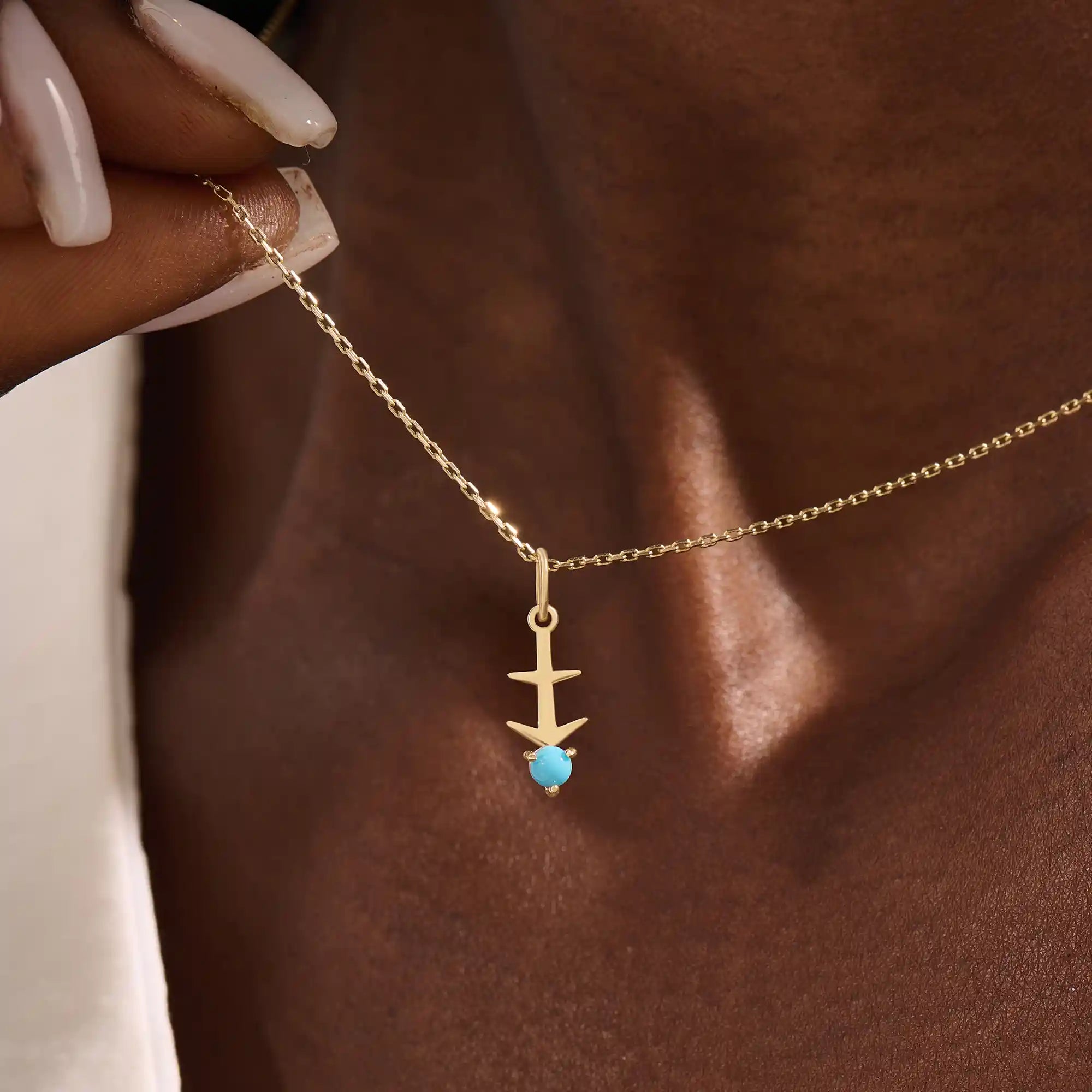 Model wears Sagittarius zodiac symbol pendant necklace in 14k solid gold with turquoise gemstone.