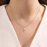 Model wears Sagittarius zodiac symbol pendant necklace in 14k solid gold with turquoise gemstone.