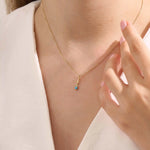 Model wears Sagittarius zodiac symbol pendant necklace in 14k solid gold with turquoise gemstone.