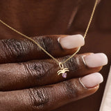 Model wears a 14k gold Aquarius zodiac pendant necklace featuring amethyst. Perfect for Aquarius zodiac birthdays and gifts.