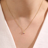 Model wears a 14k gold Aquarius zodiac pendant necklace featuring amethyst. Perfect for Aquarius zodiac birthdays and gifts.