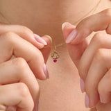 Model wears a 14k gold Cancer symbol necklace with a ruby accent. Elegant and symbolic, perfect for everyday wear or gifting.