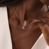 Model wears a 14k gold Cancer symbol necklace with a ruby accent. Elegant and symbolic, perfect for everyday wear or gifting.