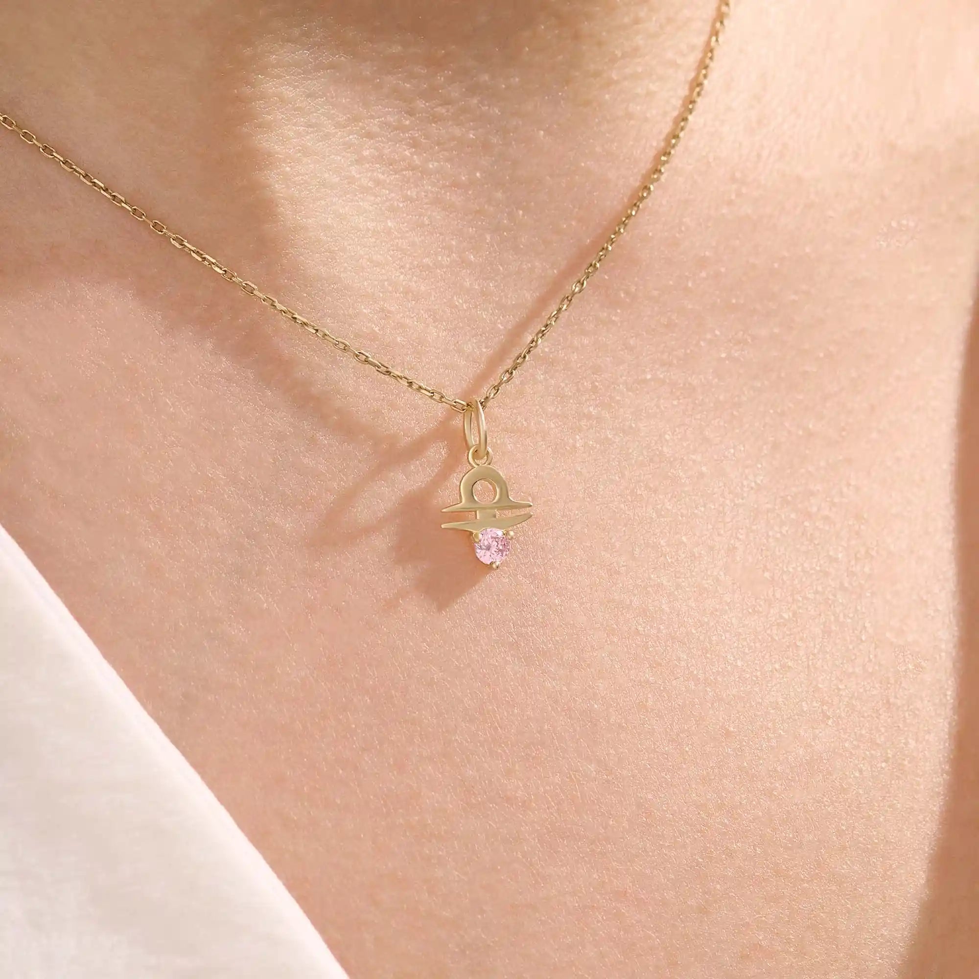 Model wears a 14k gold Libra zodiac pendant necklace featuring pink tourmaline. Perfect for Libra zodiac birthdays and gifts.