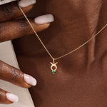 Model wears a 14k gold Taurus symbol necklace featuring an emerald stone. Stylish and meaningful for everyday wear or special gifts.