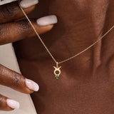 Model wears a 14k gold Taurus symbol necklace featuring an emerald stone. Stylish and meaningful for everyday wear or special gifts.