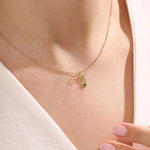 Model wears a 14k gold Taurus symbol necklace featuring an emerald stone. Stylish and meaningful for everyday wear or special gifts.