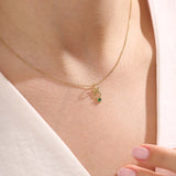 Model wears a 14k gold Taurus symbol necklace featuring an emerald stone. Stylish and meaningful for everyday wear or special gifts.