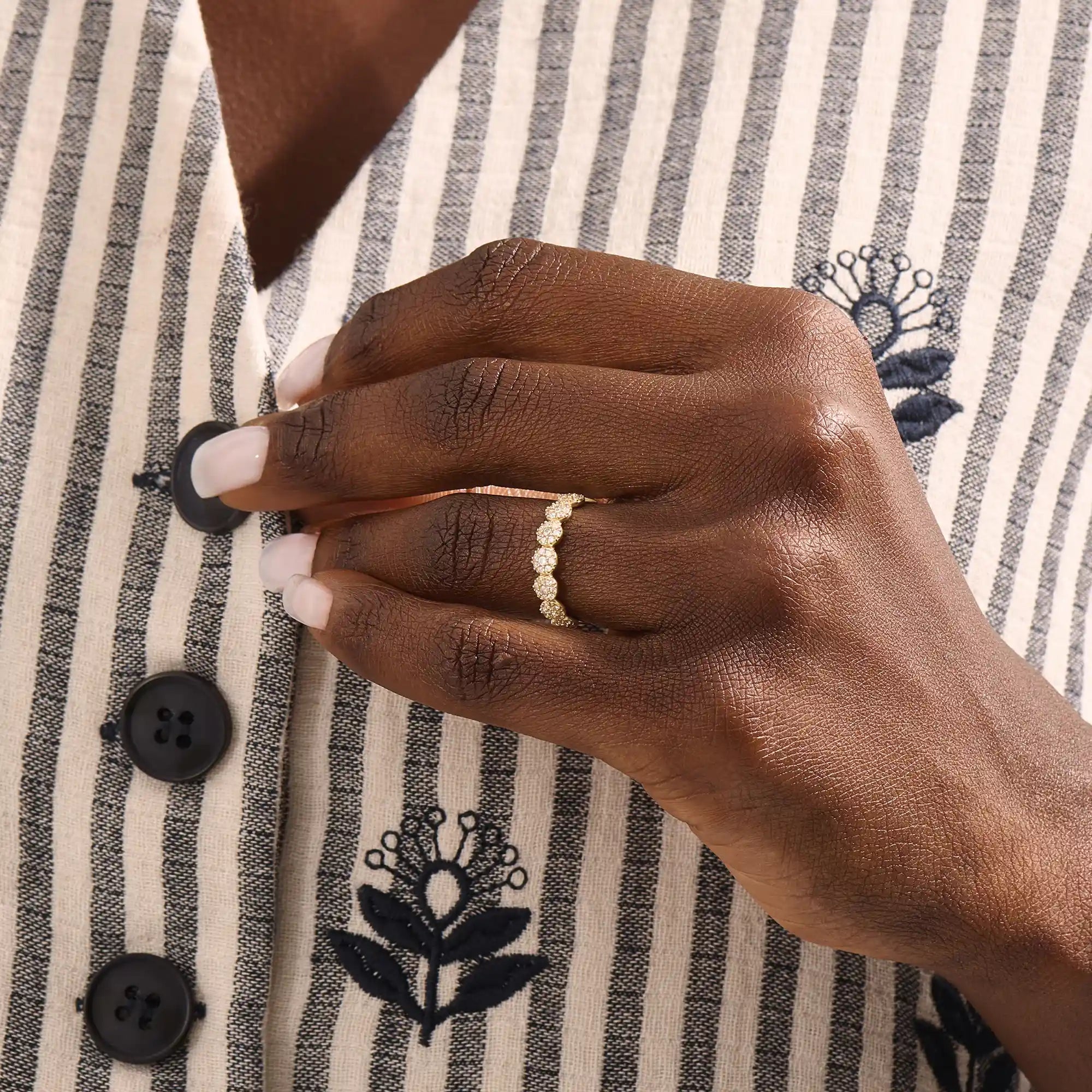 Model wears a 14k gold bold dots band ring with pave moissanites. Eye-catching statement piece for everyday style.