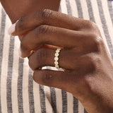 Model wears a 14k gold bold dots band ring with pave moissanites. Eye-catching statement piece for everyday style.