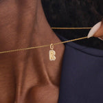 Model wears a 14k gold bubble initial necklace outlined with sparkling moissanites. Eye-catching and stylish, perfect for daily wear.