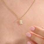 Model wears a 14k gold bubble initial necklace outlined with sparkling moissanites. Eye-catching and stylish, perfect for daily wear.
