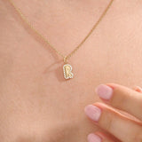 Model wears a 14k gold bubble initial necklace outlined with sparkling moissanites. Eye-catching and stylish, perfect for daily wear.