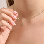 Model wears a 14k gold circle pendant necklace with clover cutout and single moissanite accent. A minimalist and meaningful everyday accessory.
