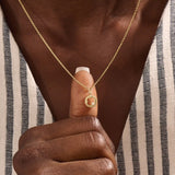 Model wears a 14k gold circle pendant necklace with clover cutout and single moissanite accent. A minimalist and meaningful everyday accessory.
