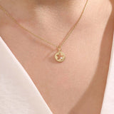 Model wears a 14k gold circle pendant necklace with star cutout and single moissanite accent. A minimalist and elegant everyday jewelry piece.