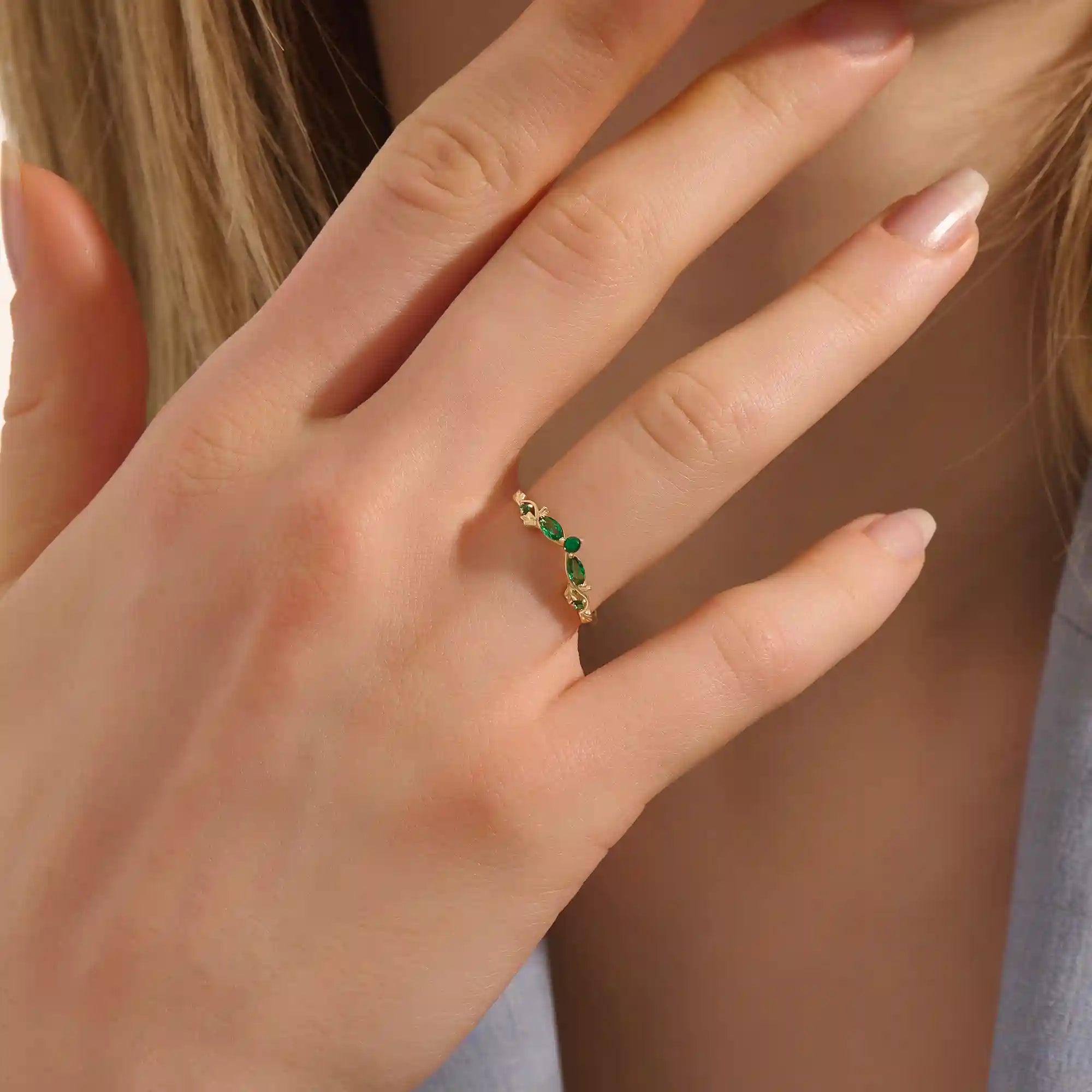Model wears a 14k gold curve nesting ring with a marquise-cut emerald gemstone. Perfect for stacking or as a subtle statement piece.