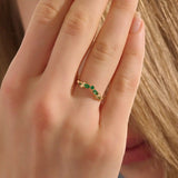 Model wears a 14k gold curve nesting ring with a marquise-cut emerald gemstone. Perfect for stacking or as a subtle statement piece.