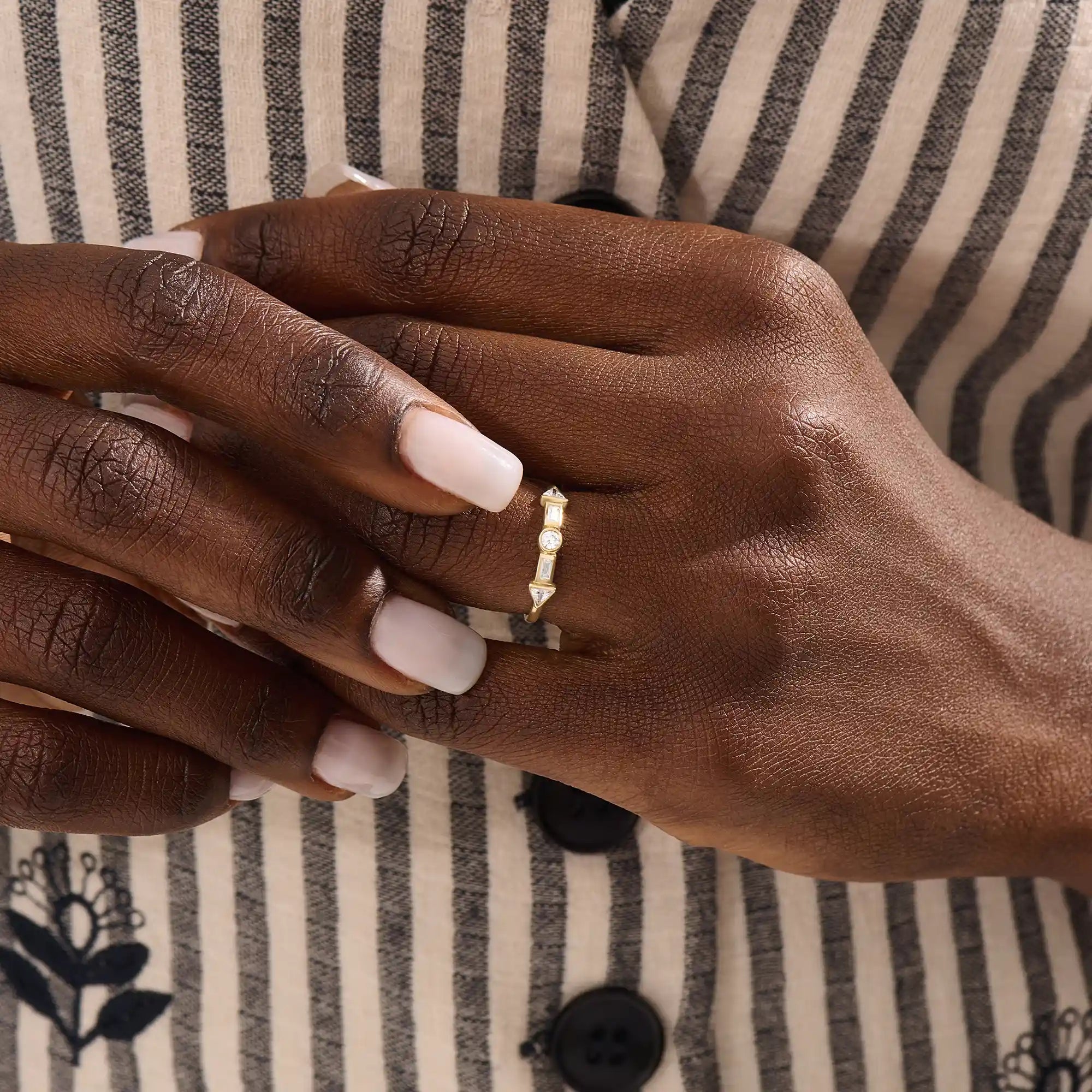 Model wears a 14k gold half eternity statement ring with bezel-set mixed cut stones. A bold and stylish piece for everyday wear.