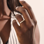 Model wears a 14k gold half eternity statement ring with bezel-set mixed cut stones. A bold and stylish piece for everyday wear.