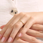 Model wears a 14k gold minimalist band ring with bezel moissanites around the band. Perfect everyday statement ring.