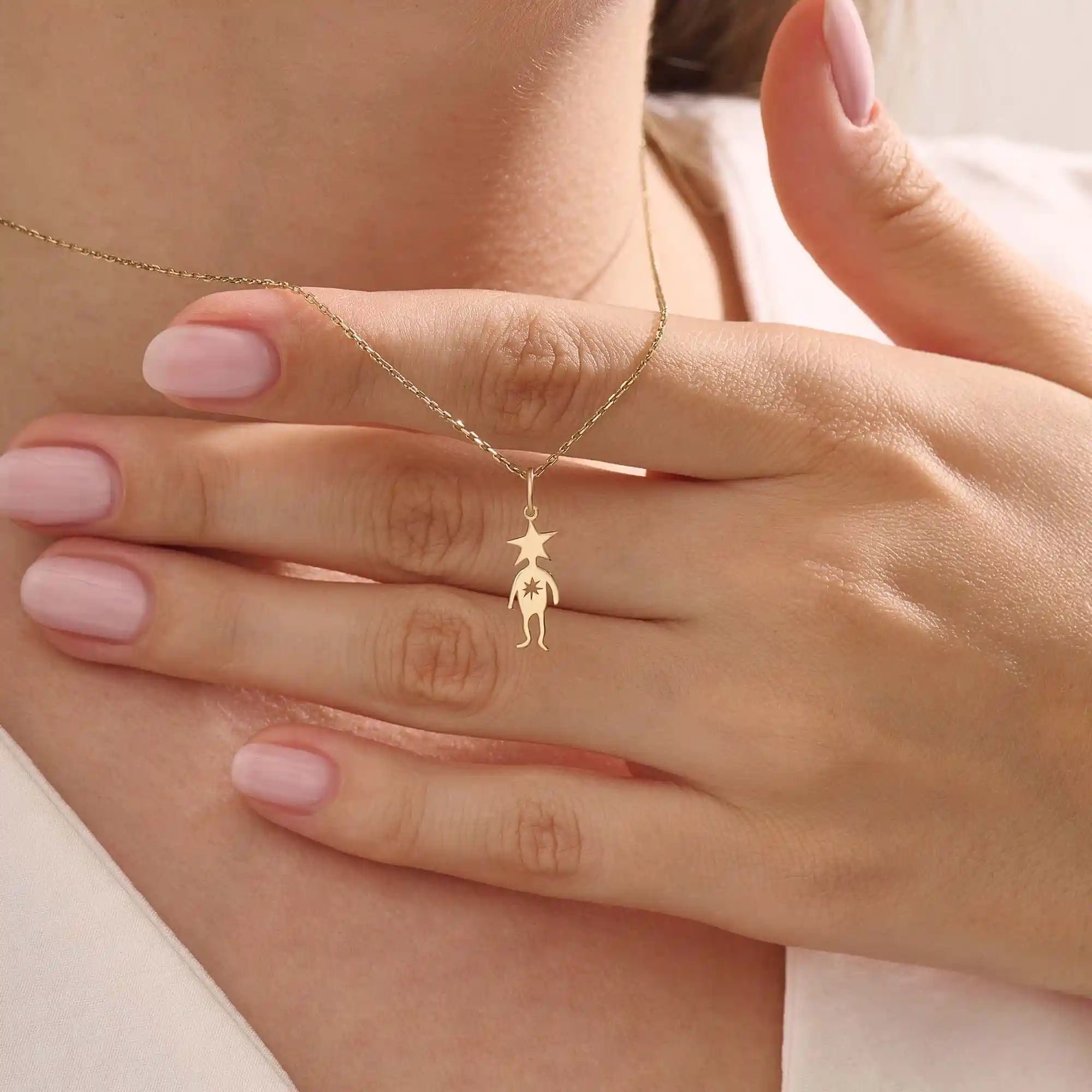 Model wears a 14k gold pendant necklace with a star head charm, perfect for little boys. A delicate and meaningful piece for daily wear.