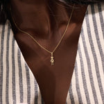 Model wears a 14k gold pendant necklace with a star head charm, perfect for little boys. A delicate and meaningful piece for daily wear.