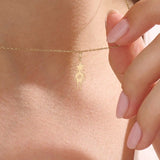 Model wears a 14k gold pendant necklace with a star head charm, perfect for little boys. A delicate and meaningful piece for daily wear.