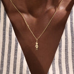 Model wears a 14k gold pendant necklace with a star head charm, perfect for little boys. A delicate and meaningful piece for daily wear.