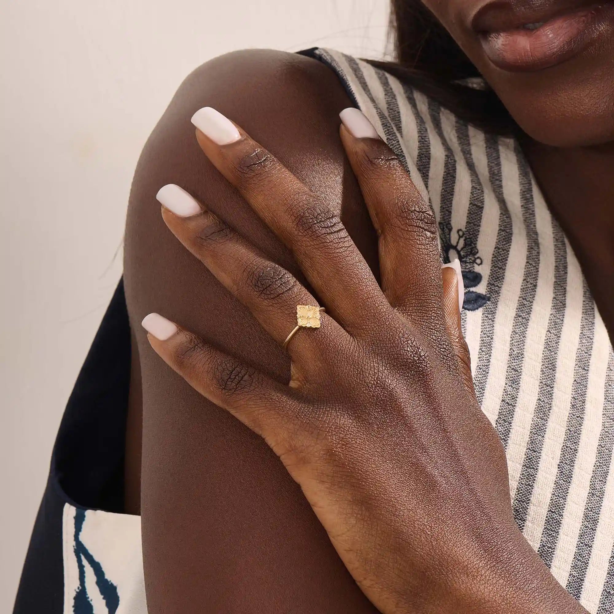 Model wears a 14k gold pinky signet ring with a clover motif. A stylish and delicate accessory perfect for layering or solo wear.