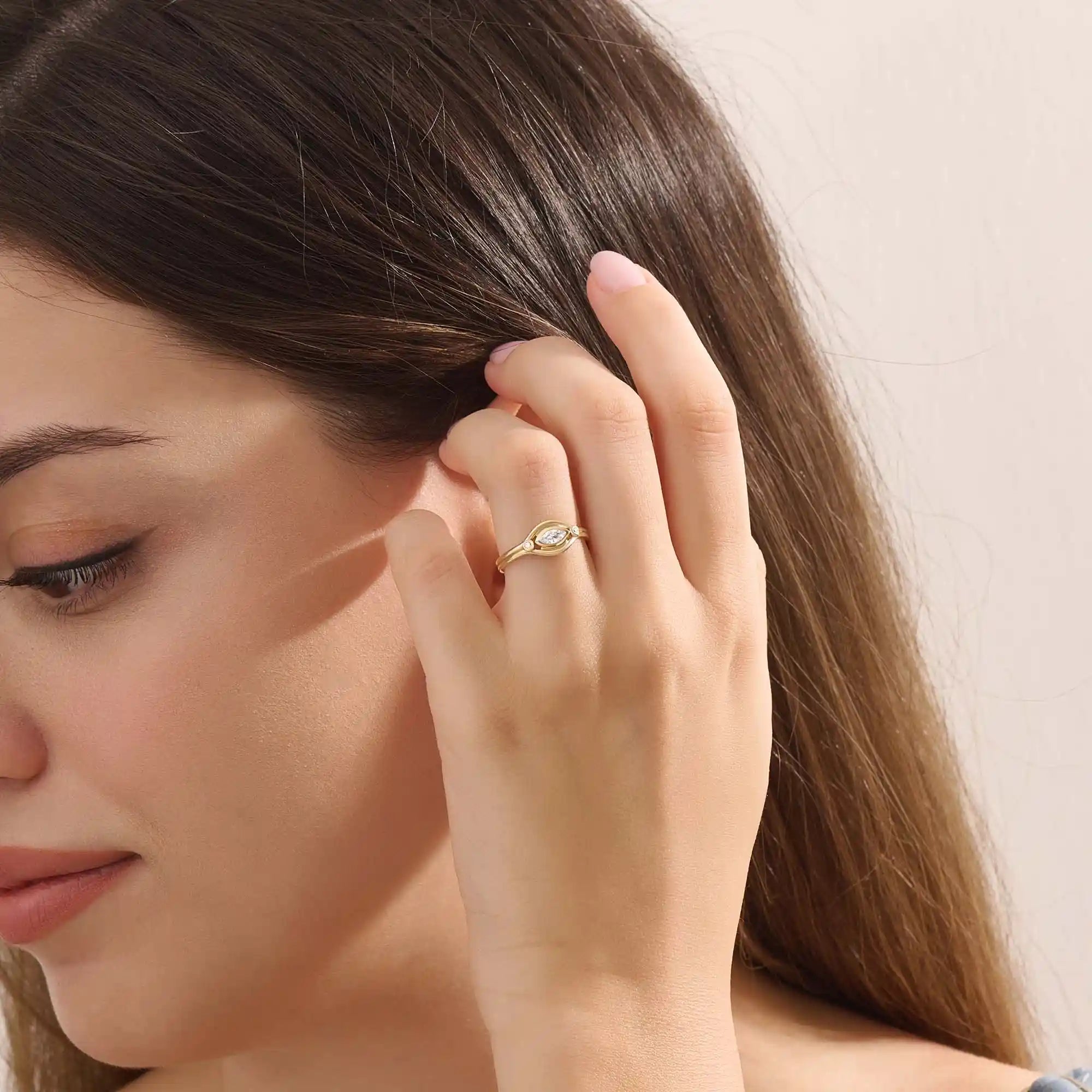 Model wears a 14k gold pinky signet ring with a marquise moissanite bezel-set evil eye motif. A unique and meaningful accessory for everyday wear.