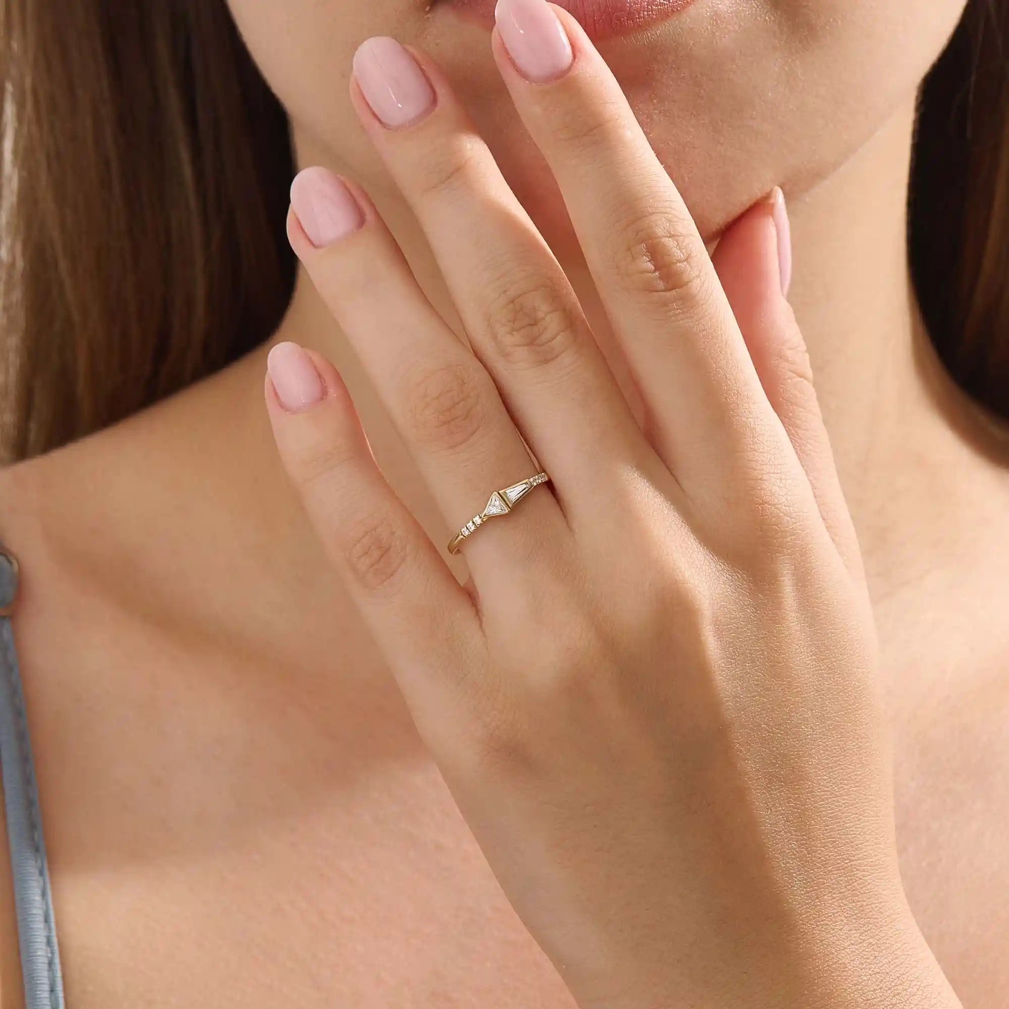 Model wears a 14k gold promise ring with mixed tapered baguette and triangle moissanite stones set in bezels. Stylish and unique for everyday or special occasions.