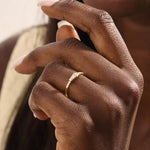 Model wears a 14k gold promise ring with mixed tapered baguette and triangle moissanite stones set in bezels. Stylish and unique for everyday or special occasions.