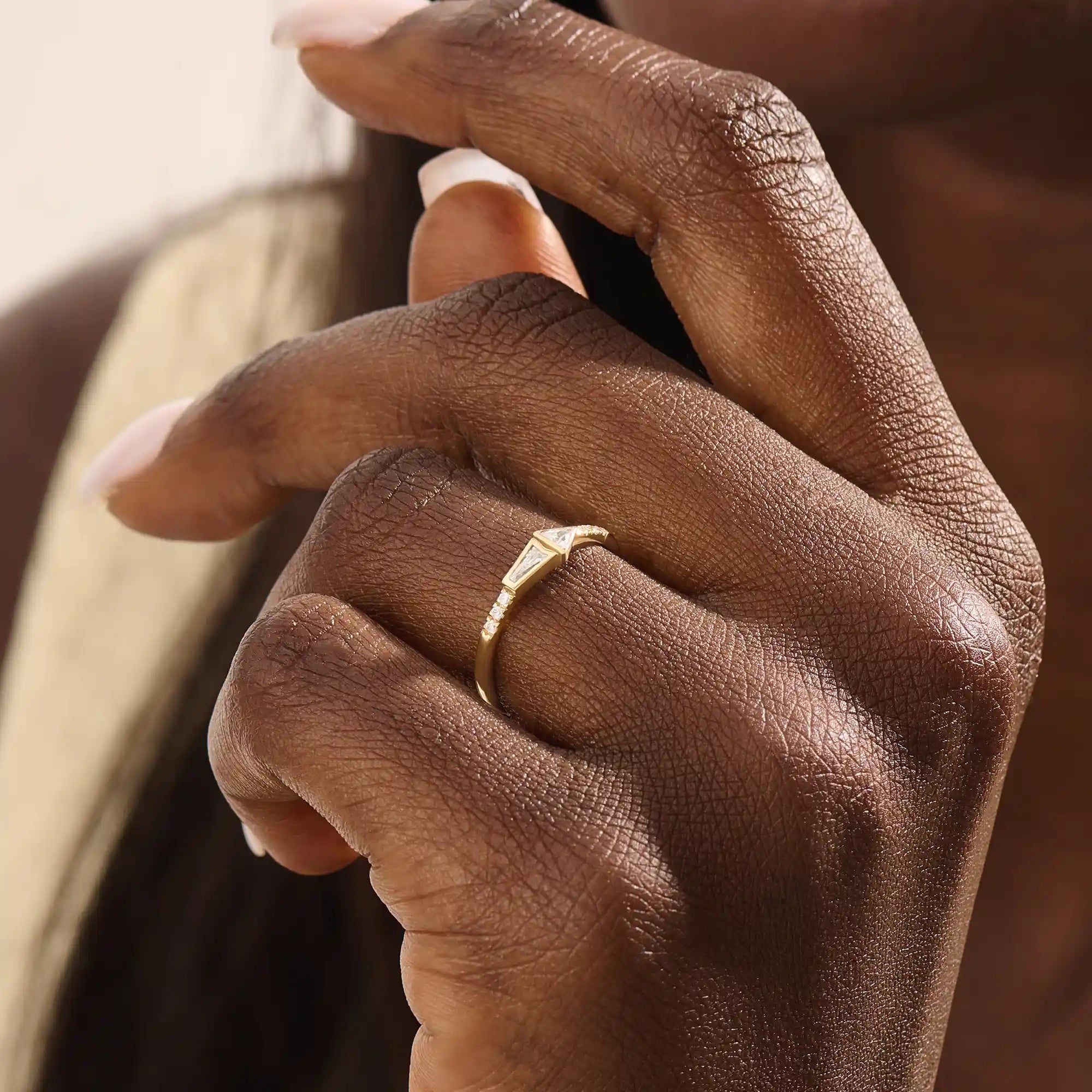 Model wears a 14k gold promise ring with mixed tapered baguette and triangle moissanite stones set in bezels. Stylish and unique for everyday or special occasions.
