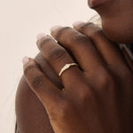 Model wears a 14k gold promise ring with mixed tapered baguette and triangle moissanite stones set in bezels. Stylish and unique for everyday or special occasions.
