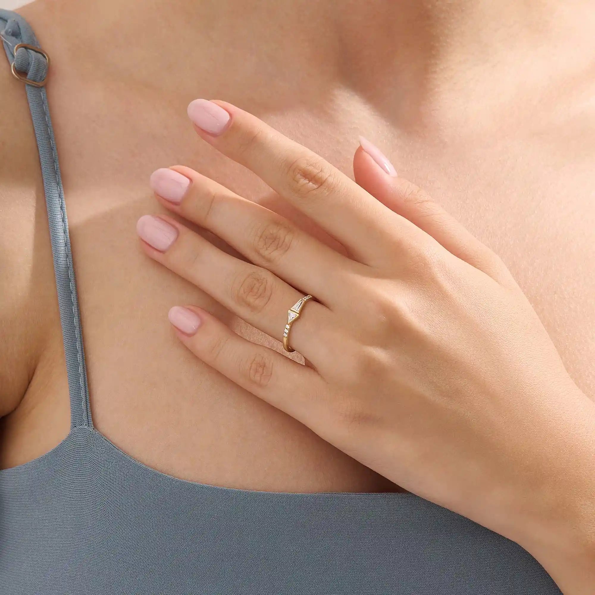 Model wears a 14k gold promise ring with mixed tapered baguette and triangle moissanite stones set in bezels. Stylish and unique for everyday or special occasions.