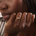 Model wears a 14k gold split band promise ring with a solo pearl centerpiece. A sleek and timeless piece ideal for layering or gifting.
