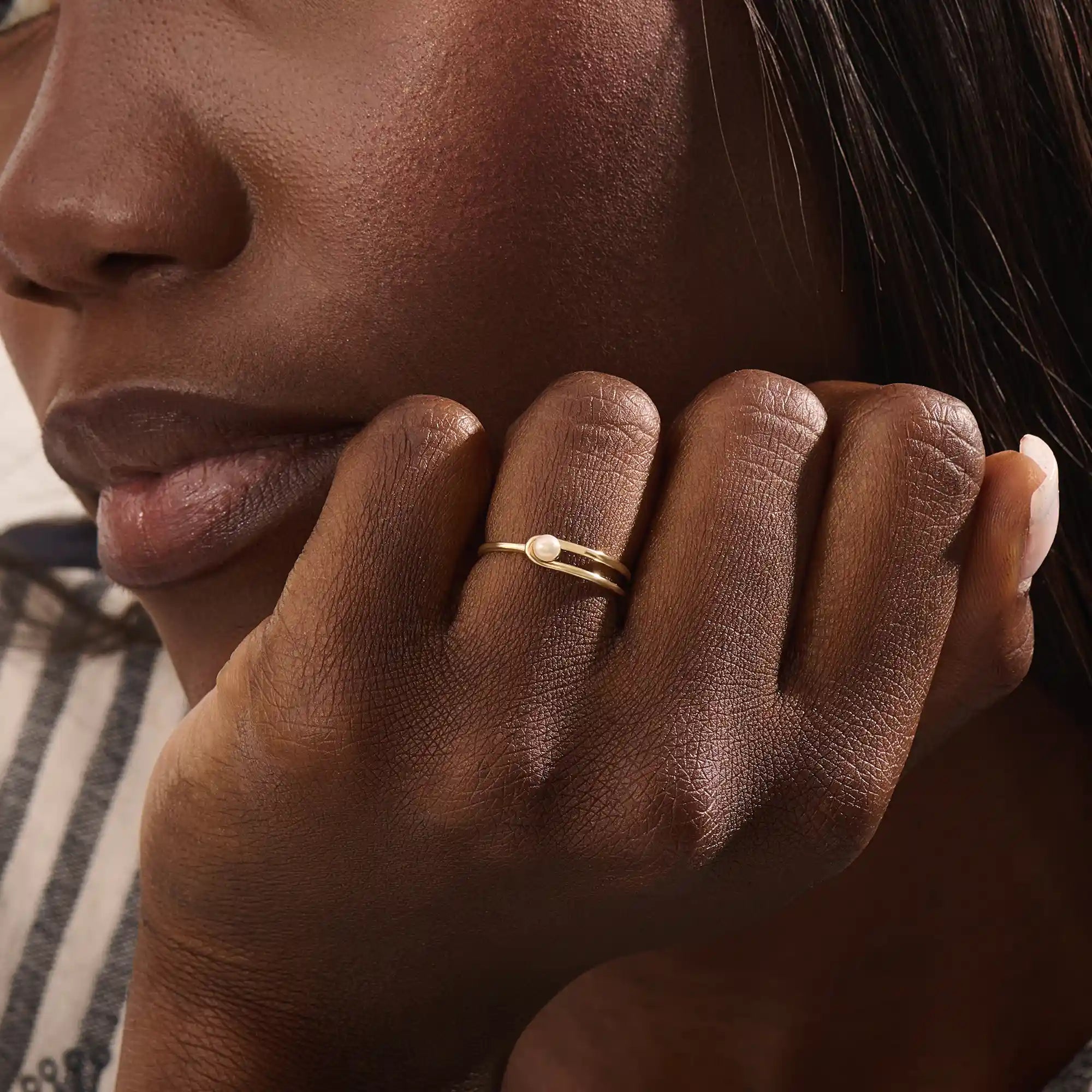 Model wears a 14k gold split band promise ring with a solo pearl centerpiece. A sleek and timeless piece ideal for layering or gifting.
