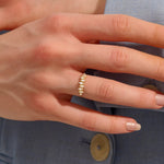 Model wears a 14k gold stacking ring featuring pavé marquise stones in an alternating ups and downs pattern. Perfect for layering with other rings.