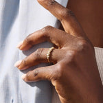 Model wears a 14k gold stacking ring featuring pavé marquise stones in an alternating ups and downs pattern. Perfect for layering with other rings.