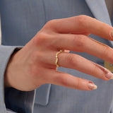 Model wears a 14k gold stacking ring with a wavy ups and downs design. Ideal for stacking or wearing solo with subtle texture.