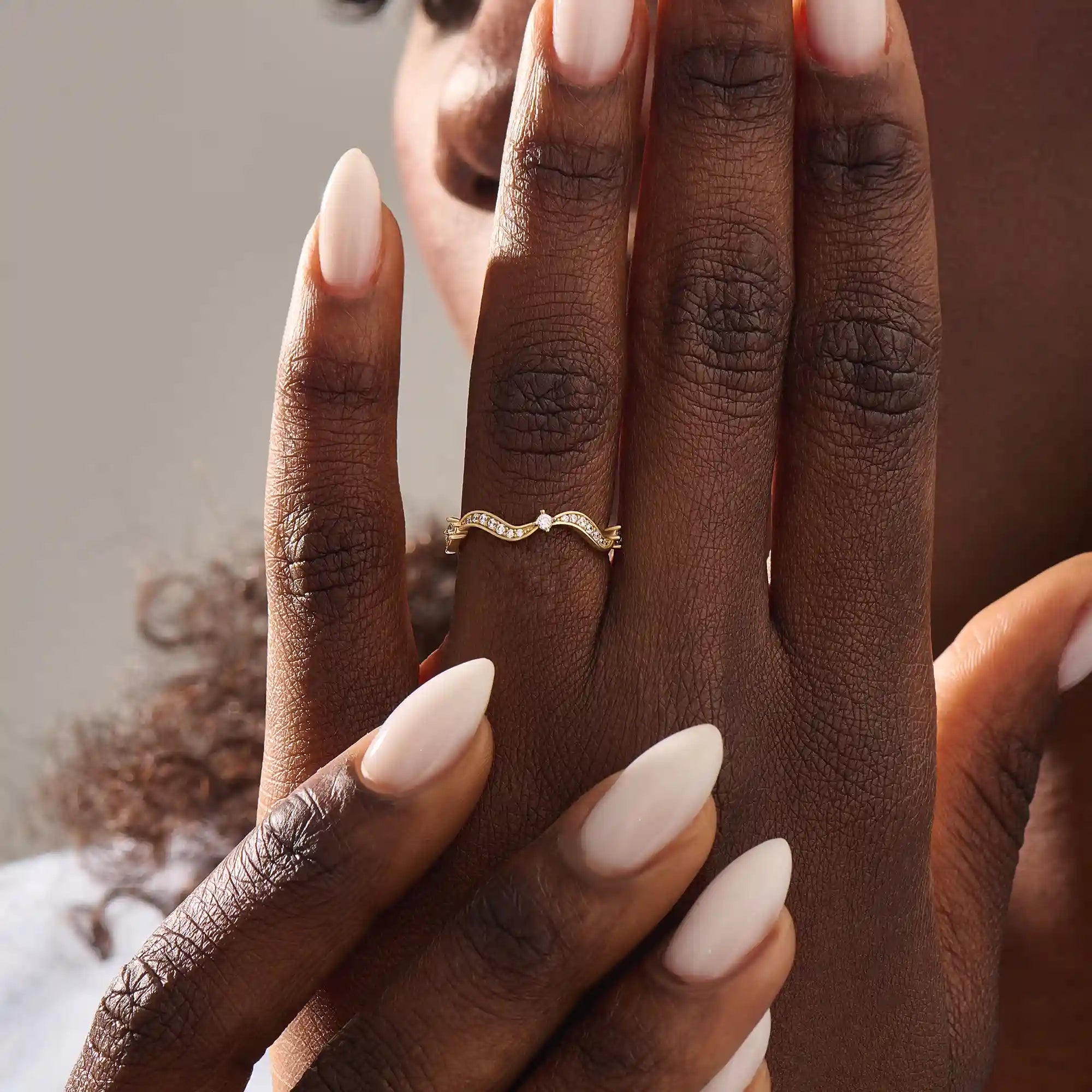 Model wears a 14k gold stacking ring with a wavy ups and downs design. Ideal for stacking or wearing solo with subtle texture.