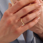 Model wears a 14k gold stacking ring with a wavy ups and downs design. Ideal for stacking or wearing solo with subtle texture.